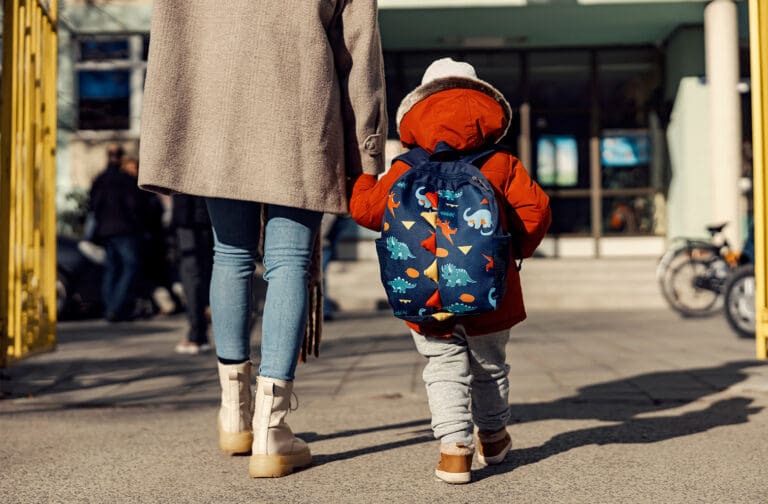 Smiling preschooler practicing early learning activities with supportive educator at Starfish Early Learning Centre