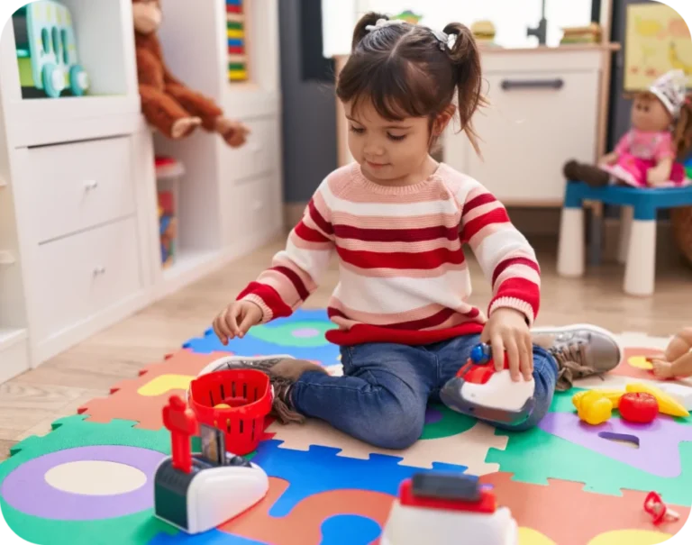 Child playing on colourful foam mat with educational toys in a bright kindergarten classroom, reflecting early childhood development focus of Starfish Early Learning Centre's funded program for 3-5 years.