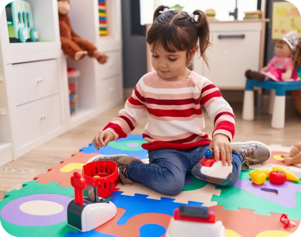 Child playing on colourful foam mat with educational toys in a bright kindergarten classroom, reflecting early childhood development focus of Starfish Early Learning Centre's funded program for 3-5 years.
