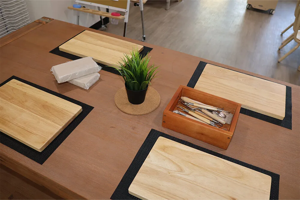 Childcare dining setup with wooden placemats and utensils prepared for shared early learning mealtime.