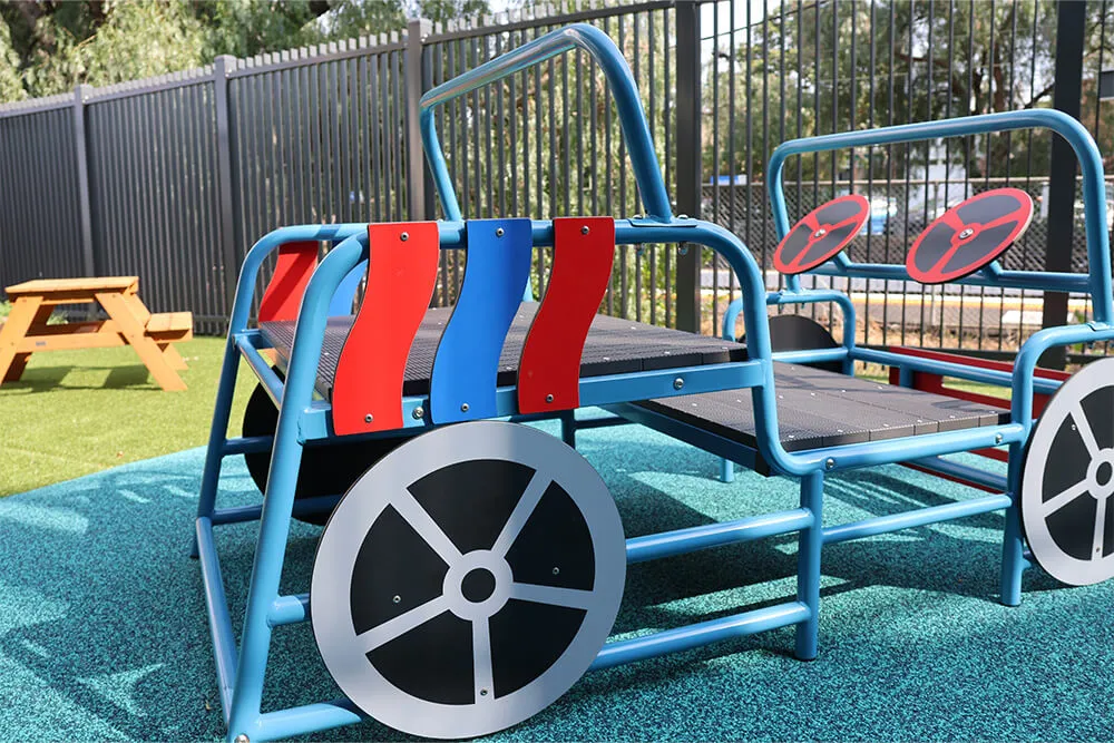 Outdoor childcare play structure shaped like a car for imaginative play and active early learning.