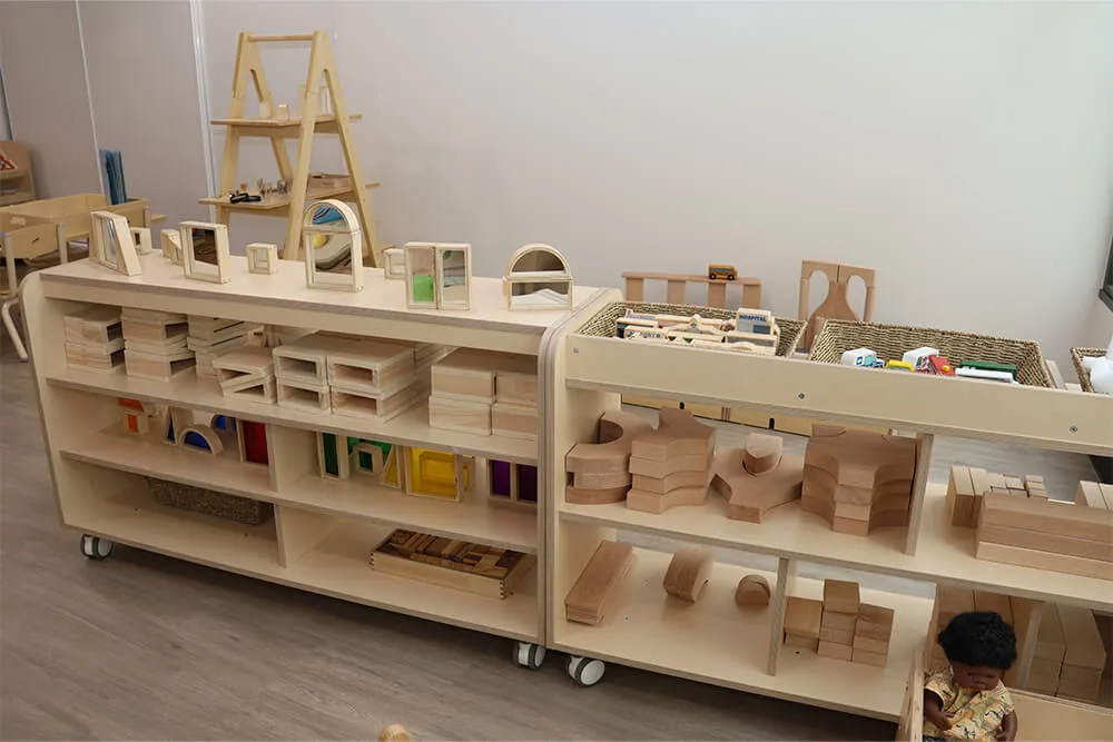 Childcare learning shelves with wooden blocks and natural materials supporting hands-on early learning.