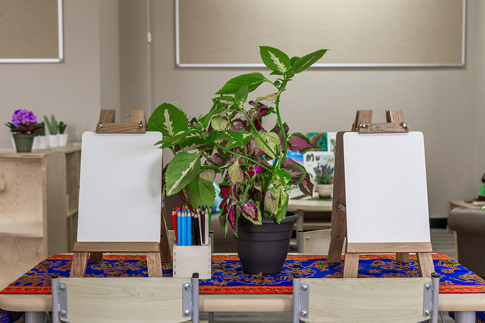 Childcare art station with easels, blank canvases and pencils supporting creative early learning and play based childcare.