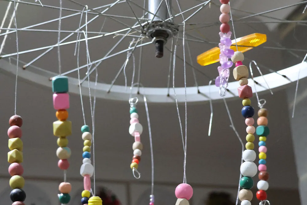 Hanging bead mobile with colourful shapes used as a sensory feature in an early learning childcare classroom.