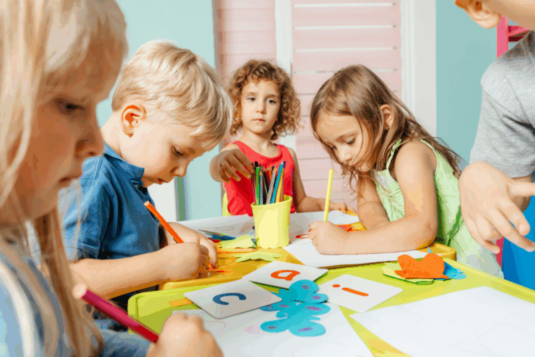 Young children engaging in creative learning activities at an early learning centre, drawing and crafting at a colourful classroom table.