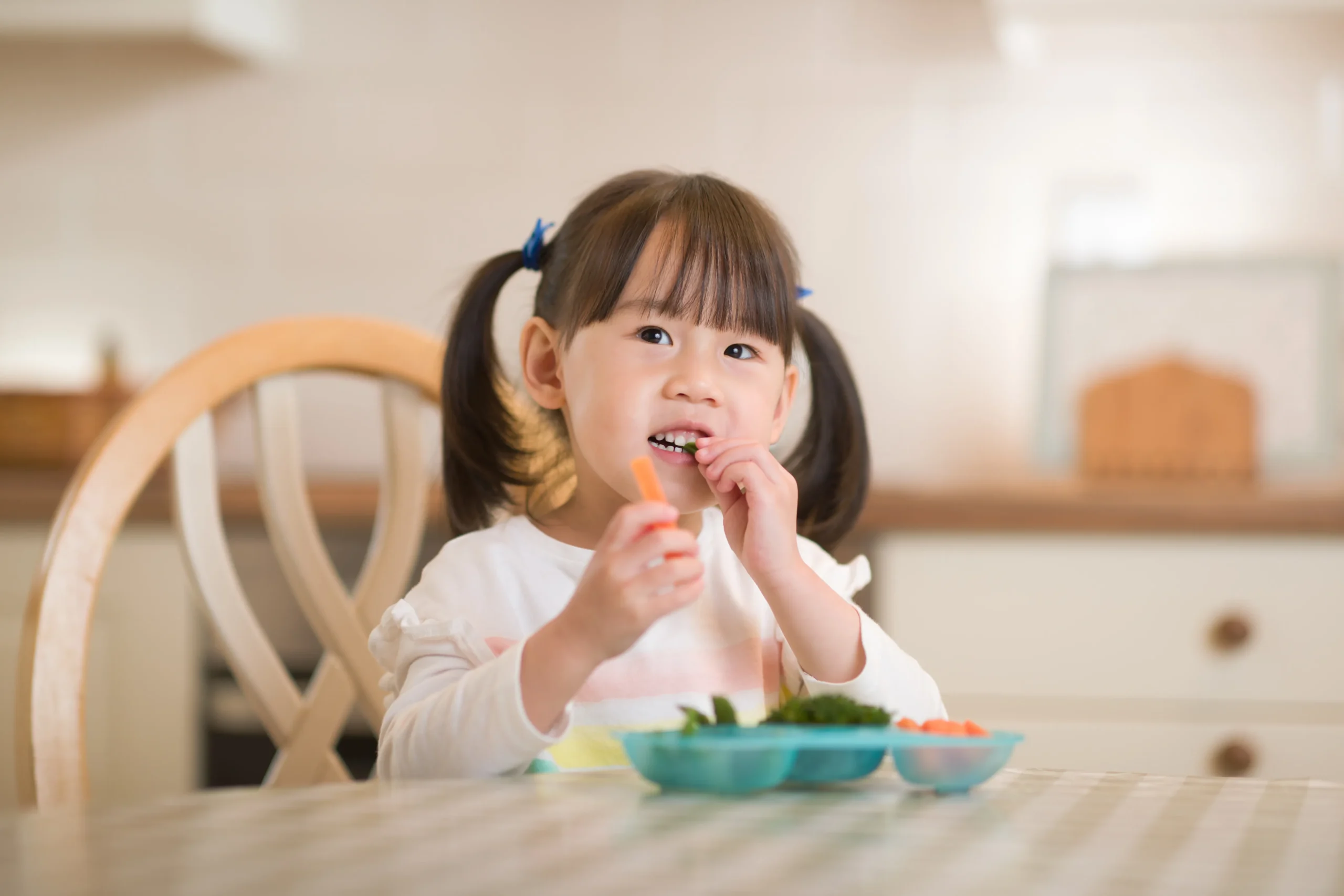 Child enjoying fresh vegetables during a healthy meal at a childcare early learning centre.
