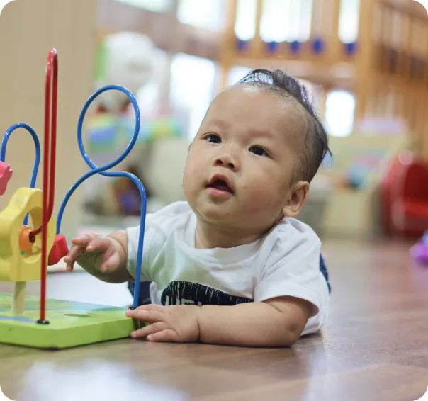 Baby exploring sensory toy in a play based childcare early learning environment.